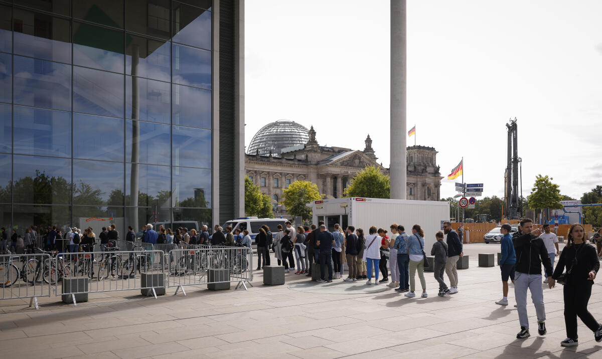 Besucherinnen und Besucher stehen am Tag der Ein- und Ausblicke des Deutschen Bundestages vor dem Paul-Löbe-Haus Schlange. Im Hintergrund ist das Reichstagsgebäude mit Kuppel zu sehen. Besucherinnen und Besucher stehen am Tag der Ein- und Ausblicke des Deutschen Bundestages vor dem Paul-Löbe-Haus Schlange. Im Hintergrund ist das Reichstagsgebäude mit Kuppel zu sehen.