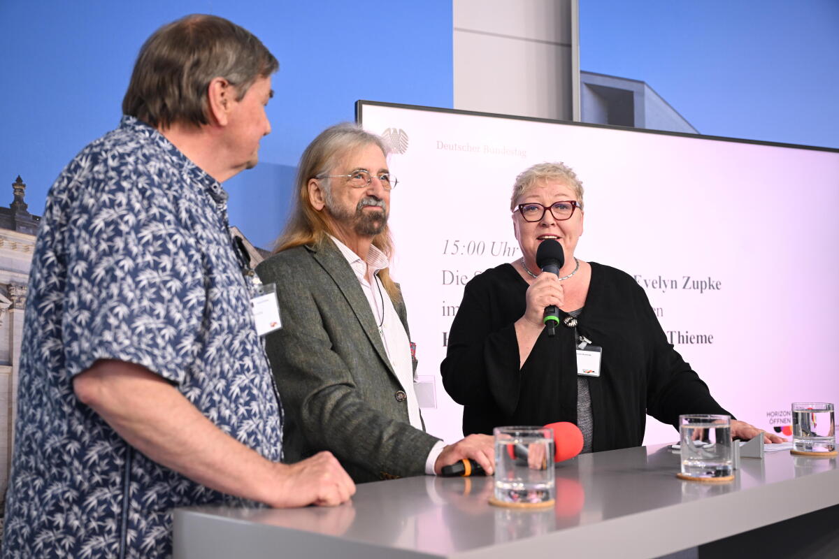 Beauftragte für die Opfer der SED-Diktatur, Evelyn Zupke, (rechts), im Gespräch mit Zeitzeuge Horst Savelsberg, (links), und Zeitzeuge Andreas Thieme (Mitte), sowie Bürgerinnen und Bürgern im Kommunikationsforum und Zelt des Deutschen Bundestages während der Feierlichkeiten zum Tag der Deutschen Einheit in Hamburg. Zupke, Evelyn; Savelsberg, Horst; Thieme, Andreas Beauftragte für die Opfer der SED-Diktatur, Evelyn Zupke, (rechts), im Gespräch mit Zeitzeuge Horst Savelsberg, (links), und Zeitzeuge Andreas Thieme (Mitte), sowie Bürgerinnen und Bürgern im Kommunikationsforum und Zelt des Deutschen Bundestages während der Feierlichkeiten zum Tag der Deutschen Einheit in Hamburg.