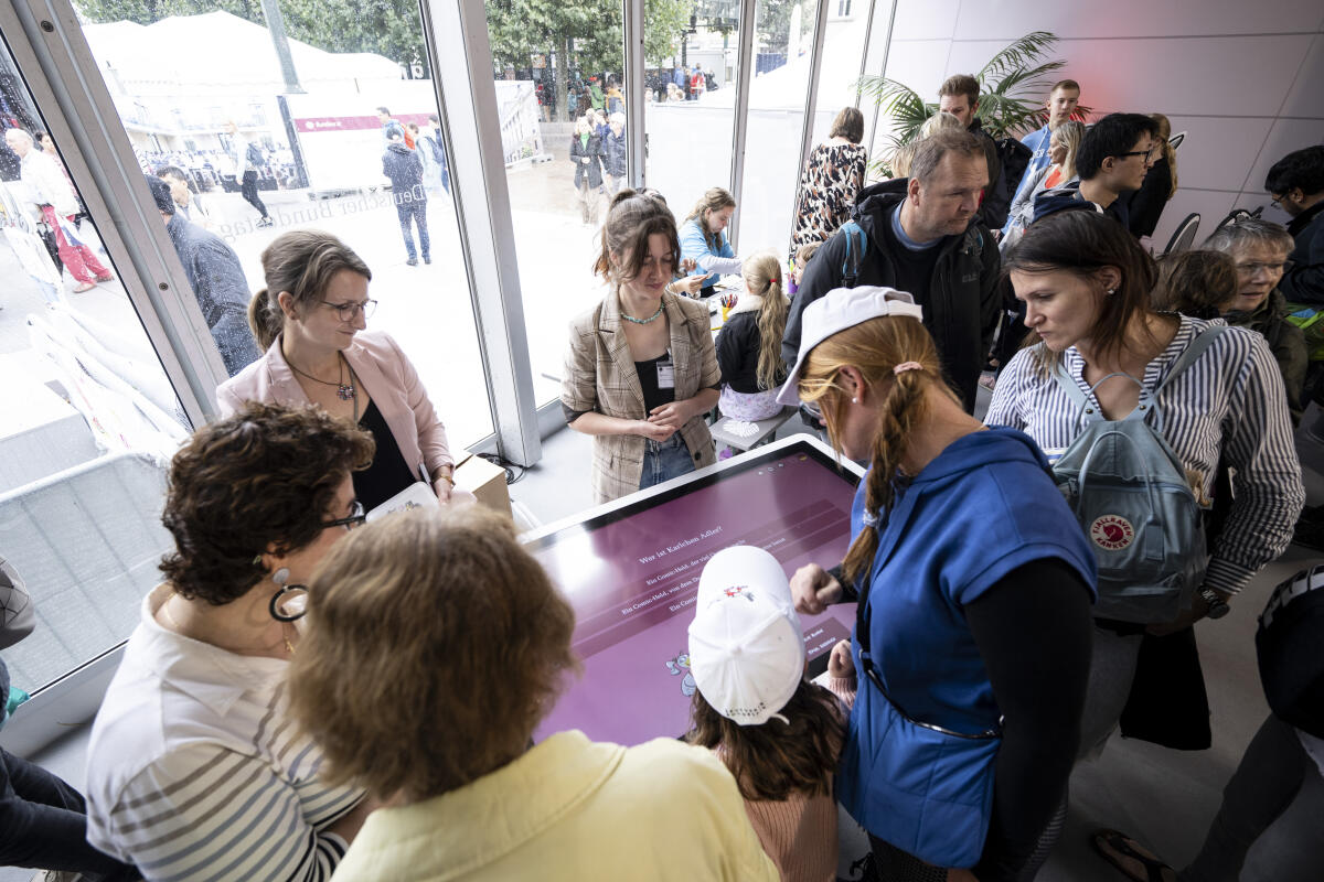 Besucherinnen und Besucher an einem Touchscreen im Kommunikationsforum und Zelt des Deutschen Bundestages auf der Festveranstaltung zum Tag der Deutschen Einheit in Hamburg. Besucherinnen und Besucher an einem Touchscreen im Kommunikationsforum und Zelt des Deutschen Bundestages auf der Festveranstaltung zum Tag der Deutschen Einheit in Hamburg.