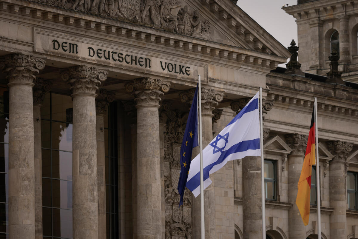  Die Flagge von Israel weht vor dem Reichstagsgebäude zwischen der deutschen und der europäischen Flagge.