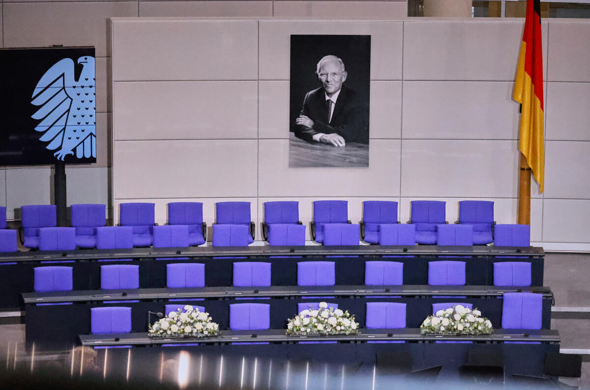 Trauerstaatsakt für den verstorbenen Bundestagspräsidenten a.D. Dr. Wolfgang Schäuble im Plenarsaal des Deutschen Bundestages. Blick auf das Portrait des Verstorbenen oberhalb der Regierungsbank, die mit weißen Blumengestecken geschmückt ist. Trauerstaatsakt für den verstorbenen Bundestagspräsidenten a.D. Dr. Wolfgang Schäuble im Plenarsaal des Deutschen Bundestages. Blick auf das Portrait des Verstorbenen oberhalb der Regierungsbank, die mit weißen Blumengestecken geschmückt ist.