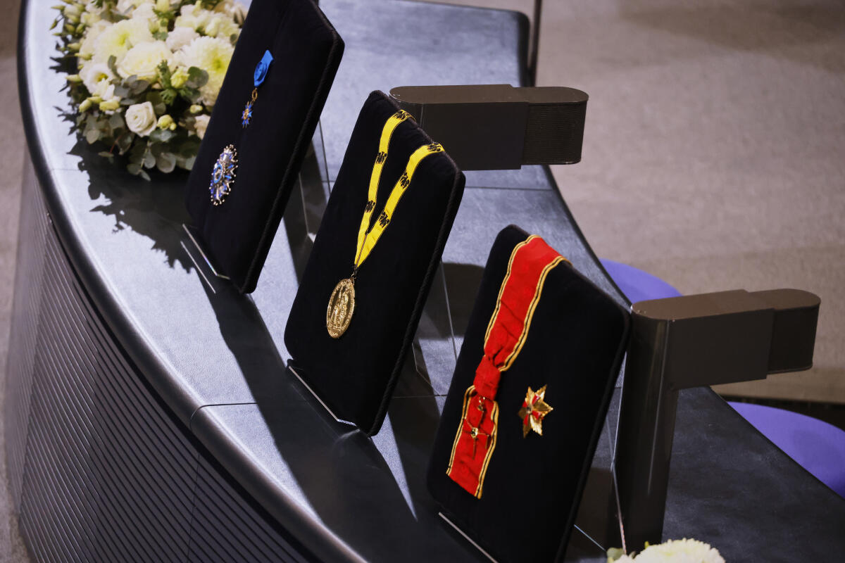  Trauerstaatsakt für den verstorbenen Bundestagspräsidenten a.D. Dr. Wolfgang Schäuble im Plenarsaal des Deutschen Bundestages. Blick auf Ordenskissen auf der Stenographenbank mit den höchsten Orden des Verstorbenen, verliehen durch die Bundesrepublik Deutschland und die Französische Republik bzw. Medaille des Internationalen Karlspreises zu Aachen.