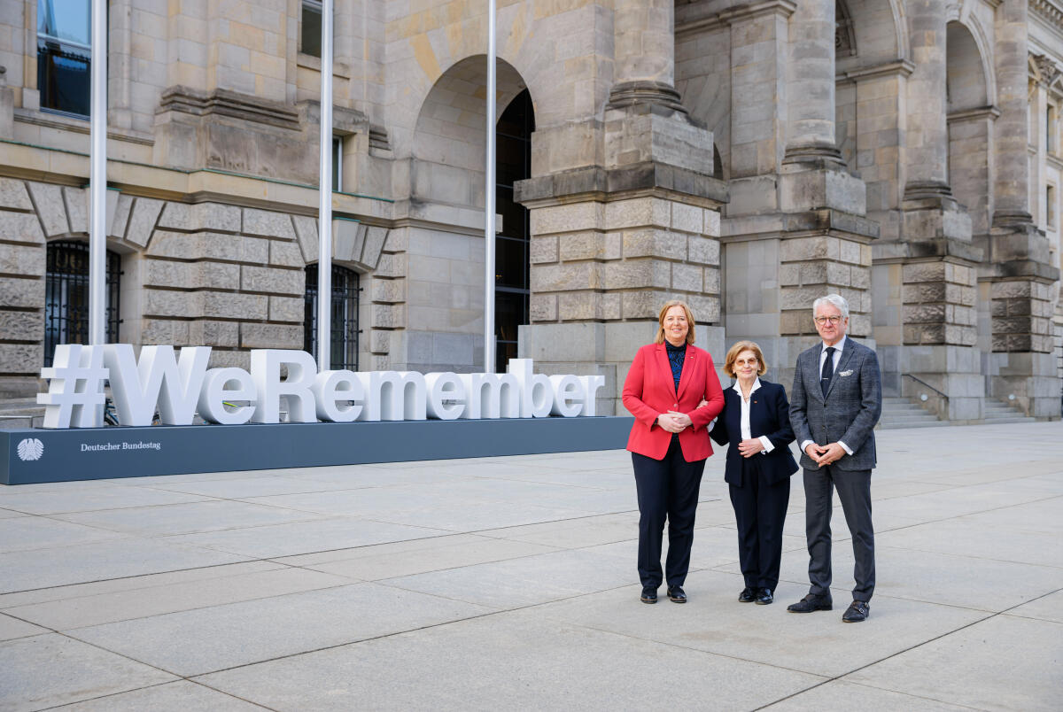 Bas, Bärbel; Szepesi, Eva; Reif, Marcel Gemeinsames Gruppenfoto mit Bundestagspräsidentin Bärbel Bas, SPD, MdB, (links), Gastrednerin Eva Szepesi, Holocaust-Überlende, (Mitte), sowie Gastredner Marcel Reif, Sportjournalist, (rechts), vor dem Schriftzug der internationalen Gedenkkampagne des Jüdischen Weltkongresses und der UNESCO #WeRemember auf dem Friedrich-Ebert-Platz vor dem Reichstagsgebäude.