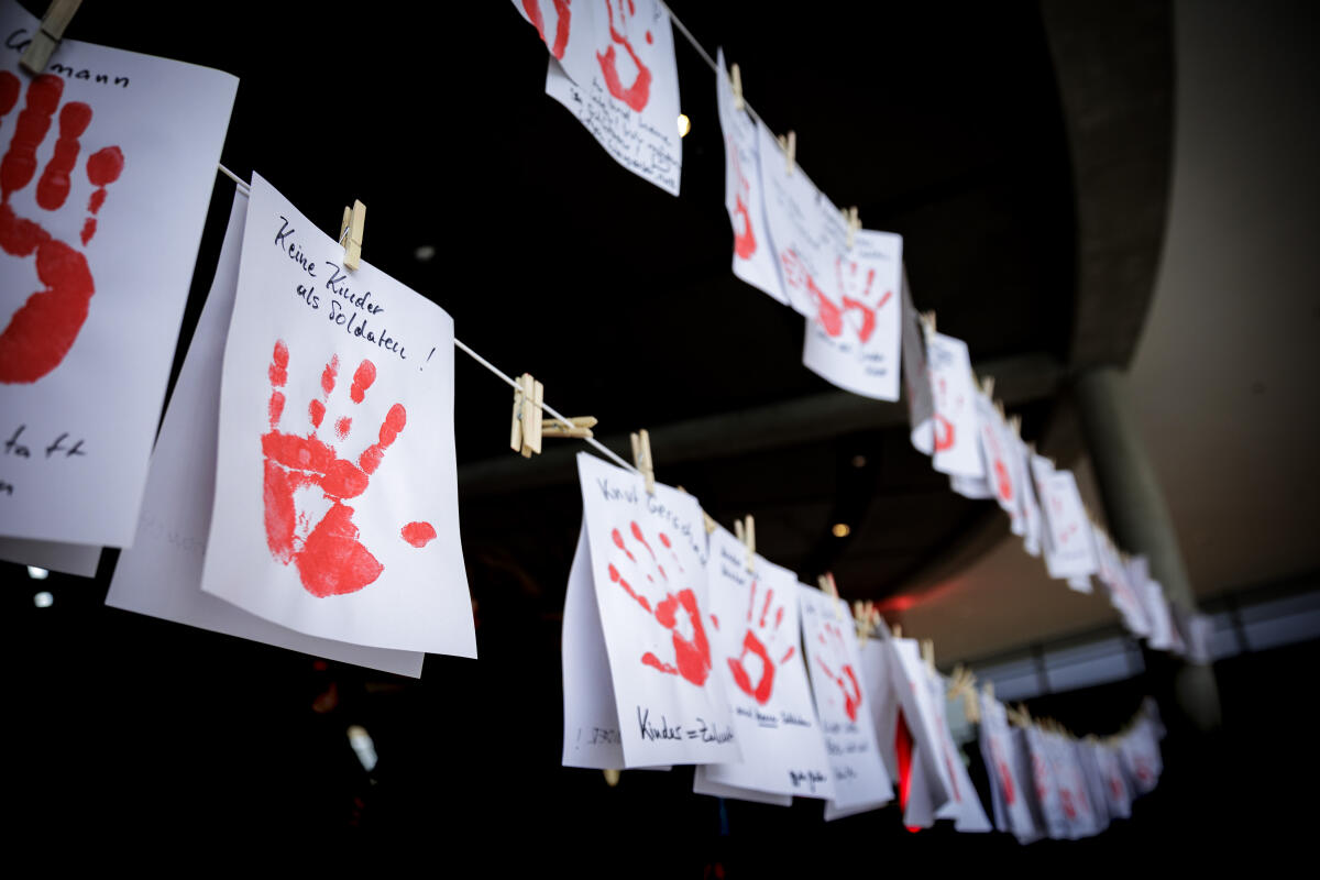 Aktion Rote Hand/Red Hand Day 2024 gegen den Einsatz von Kindern und Jugendlichen in Kriegen. Blick auf rote Handabdrücke auf Papier nebeneinander an zwei Leinen angebracht. Die gesammelten Handabdrücke leitet die Kinderkommission (Kiko) an die Vereinten Nationen weiter. Aktion Rote Hand/Red Hand Day 2024 gegen den Einsatz von Kindern und Jugendlichen in Kriegen. Blick auf rote Handabdrücke auf Papier nebeneinander an zwei Leinen angebracht. Die gesammelten Handabdrücke leitet die Kinderkommission (Kiko) an die Vereinten Nationen weiter.