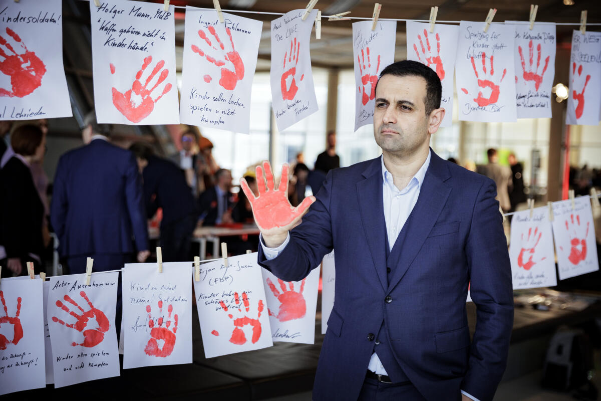 Aktion Rote Hand/Red Hand Day 2024 gegen den Einsatz von Kindern und Jugendlichen in Kriegen. Hier im Bild Bijan Djir-Sarai, FDP, MdB, mit seiner rot bemalten Hand zur Teilnahme an der Aktion der Kinderkommission (Kiko) des Deutschen Bundestages. Im Hintergrund rote Handabdrücke auf Papier nebeneinander an zwei Leinen angebracht. Djir-Sarai, Bijan Aktion Rote Hand/Red Hand Day 2024 gegen den Einsatz von Kindern und Jugendlichen in Kriegen. Hier im Bild Bijan Djir-Sarai, FDP, MdB, mit seiner rot bemalten Hand zur Teilnahme an der Aktion der Kinderkommission (Kiko) des Deutschen Bundestages. Im Hintergrund rote Handabdrücke auf Papier nebeneinander an zwei Leinen angebracht.