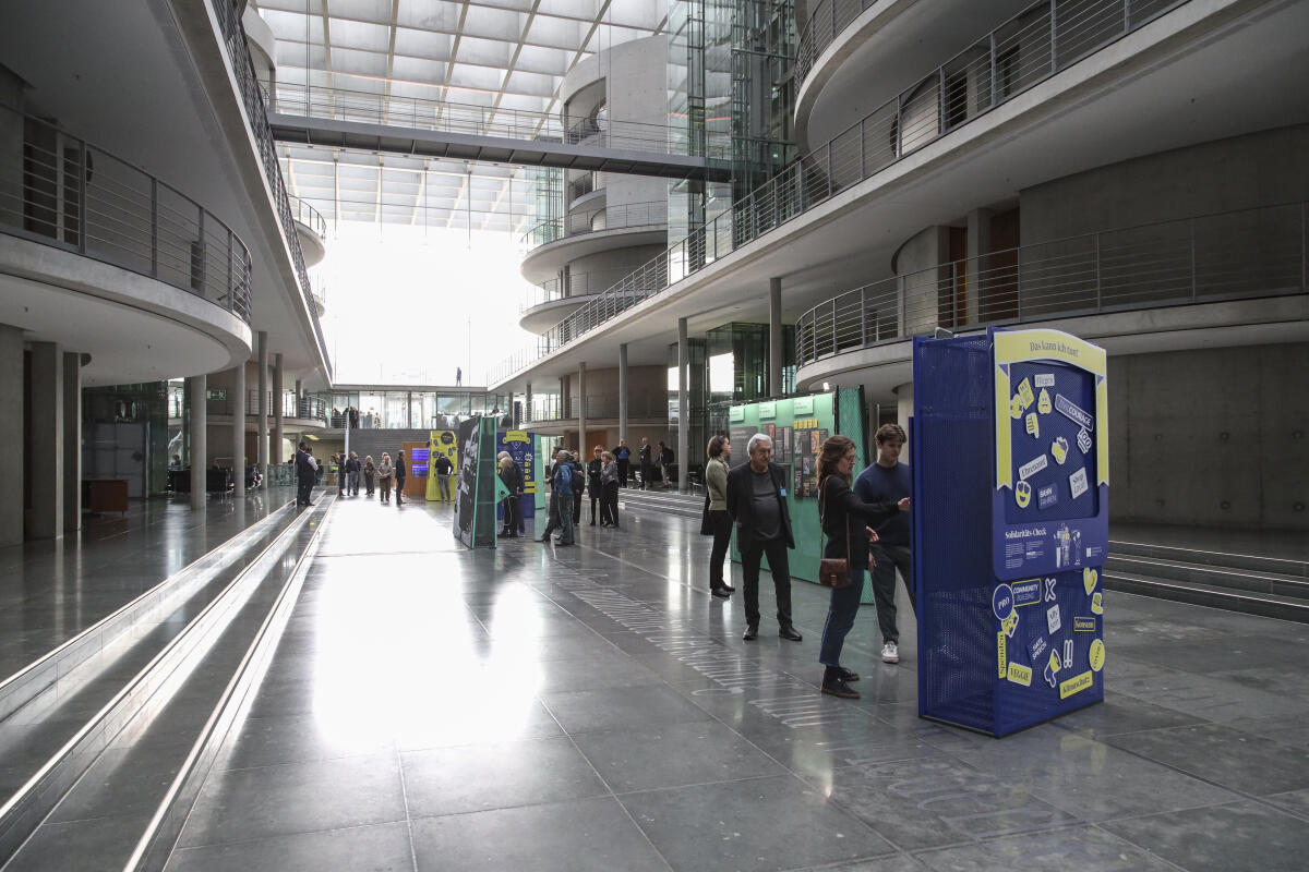  Besucherinnen und Besucher in der Ausstellung „#Challenging Democracy - von Helmut Schmidt bis heute" vor deren Eröffnung in der Halle des Paul-Löbe-Hauses. 