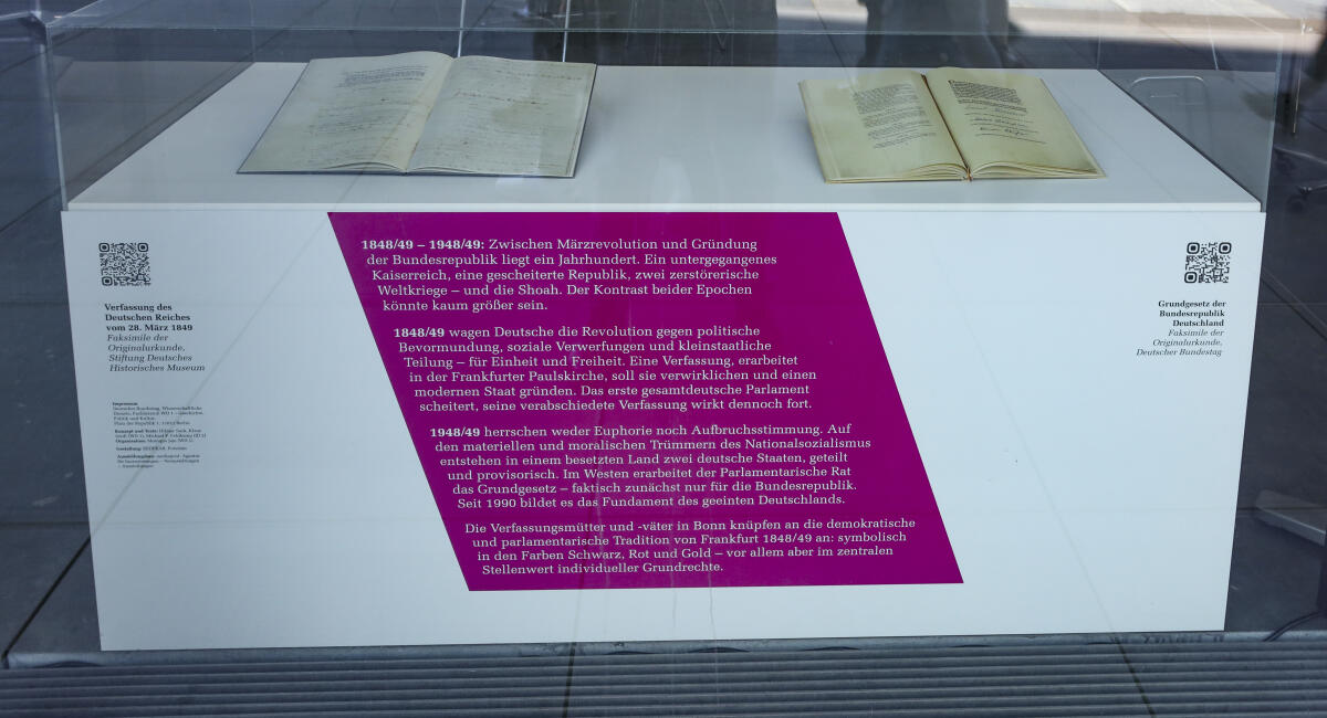  „48/49: Zwei Jahre, zwei Epochen, zwei Verfassungen – Ein Land“: Unter diesem Titel zeichnet eine neue Ausstellung des Deutschen Bundestages Kontinuitäten und Brüche in der deutschen Verfassungsgeschichte nach – von der Revolution 1848/49 bis zum Gründungsprozess der Bundesrepublik 1948/49. Die Ausstellung hängt bis Anfang September in den Fenstern des Paul-Löbe-Hauses und ist für die Öffentlichkeit vom Spreeuferweg aus zu sehen.; Blick auf eine Vitrine mit den Faksimiles von der Verfassung des Deutschen Reiches vom 28. März 1849, (links), und dem Faksimile vom Grundgesetz der Bundesrepublik Deutschland, (rechts).