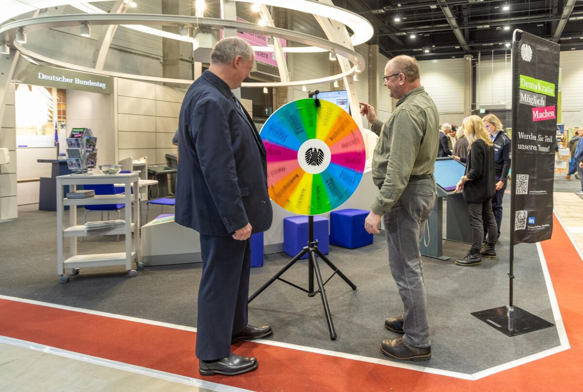  Messestand des Deutschen Bundestages auf der Grünen Woche in Berlin. Hier ein Mitarbeiter der Bundestagverwaltung am Glücksrad mit einem Besucher.