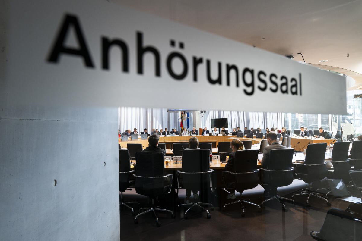 Bär, Dorothee; Durz, Hansjörg Gespräch mit Bundesministerin Dorothee Bär zum Thema Staatsmodernisierung sowie zu den digitalpolitischen Vorhaben des Bundesministeriums für Forschung, Technologie und Raumfahrt im Ausschuss für Digitales und Staatsmodernisierung. Hier Blick durch die Glastür mit der Aufschrift "Anhörungssaal" in den Saal.