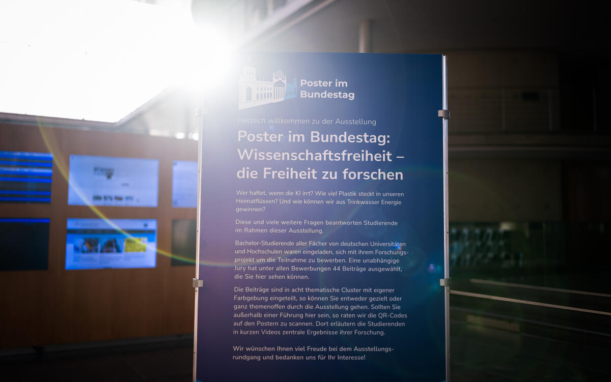  Eröffnung der Ausstellung "Poster im Bundestag: Wissenschaftsfreiheit - die Freiheit zu forschen" in der Halle des Paul-Löbe-Hauses: Blick auf einen Aufsteller der Ausstellung mit einer Lichtreflexion der Sonne (Lens Flares).