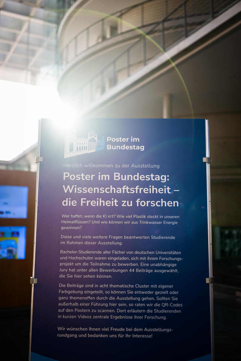 Eröffnung der Ausstellung "Poster im Bundestag: Wissenschaftsfreiheit - die Freiheit zu forschen" in der Halle des Paul-Löbe-Hauses: Blick auf einen Aufsteller der Ausstellung mit einer Lichtreflexion der Sonne (Lens Flares).